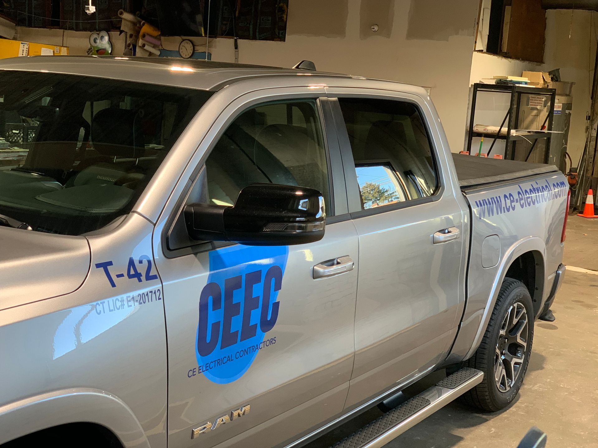 Silver CEEC pickup truck with blue logo, parked indoors.