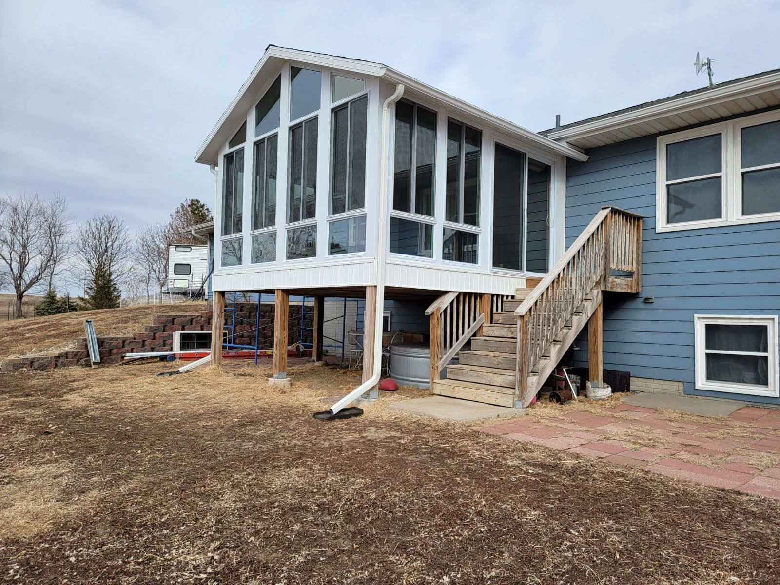 A blue house with sunroom and stairs