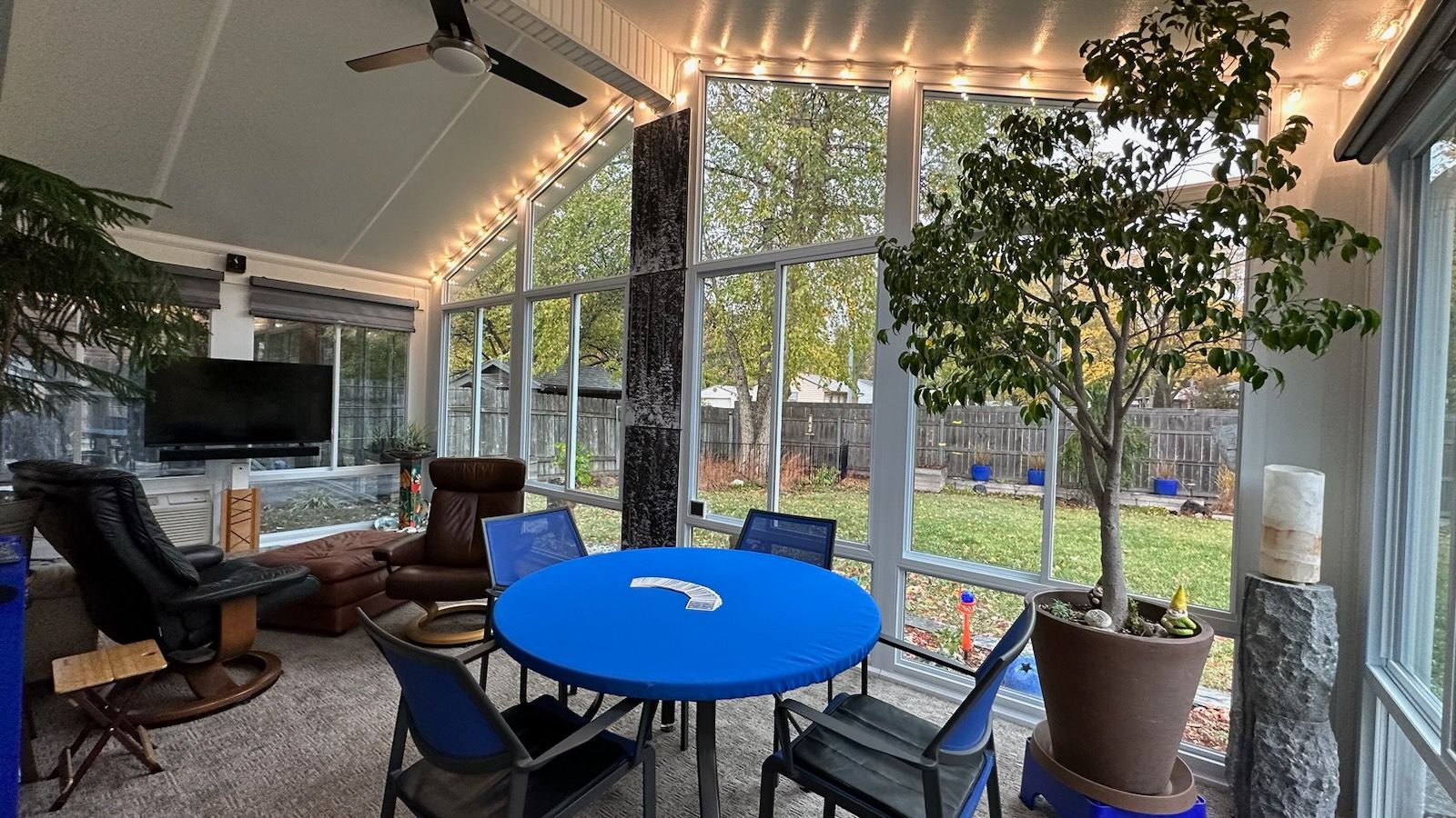 A sunroom with a table and chairs and a blue table cloth