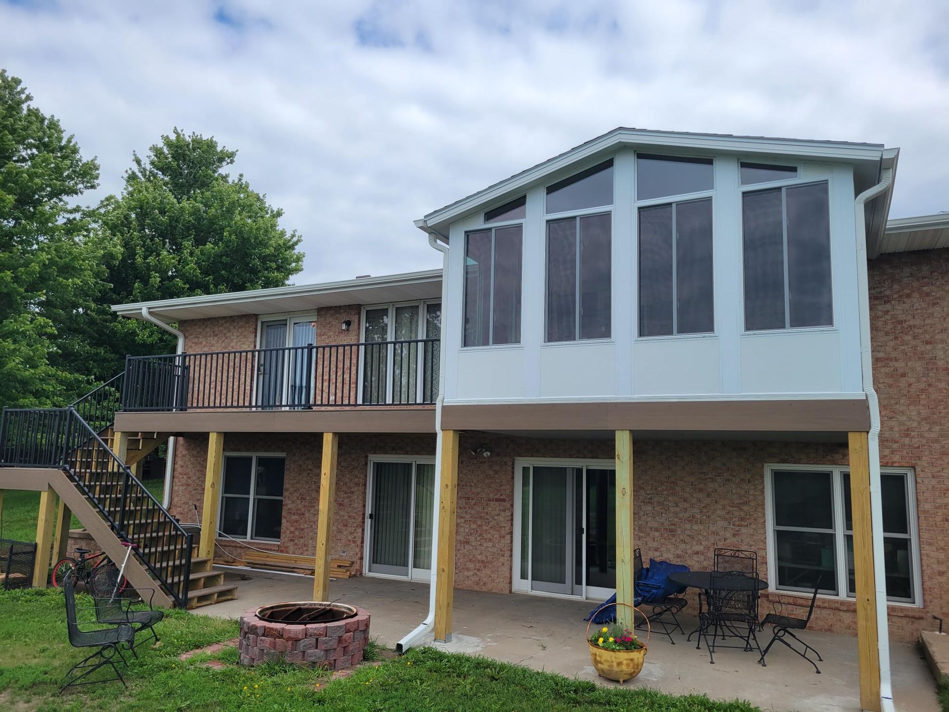 The back of a brick house with a deck and stairs