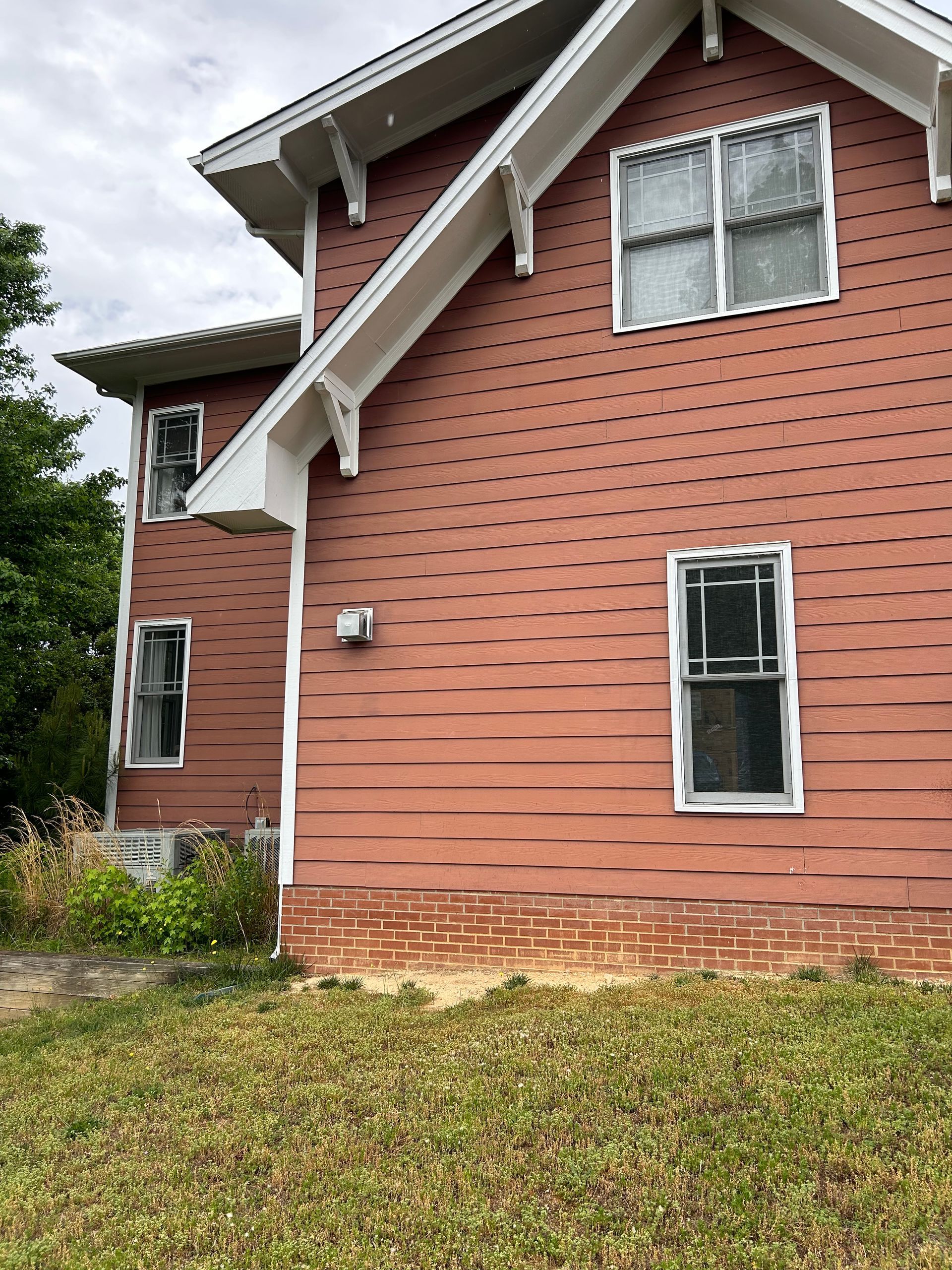 A large red brick house with white trim and windows