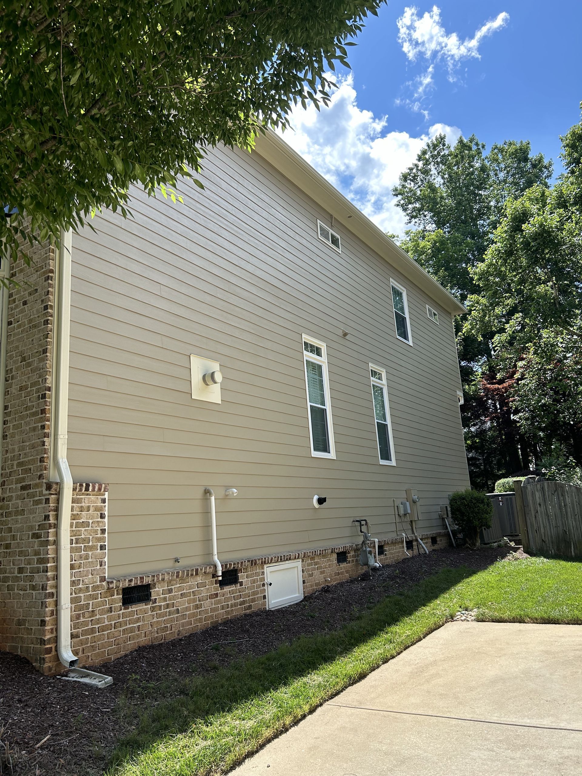 The side of a house with a lot of windows and a driveway