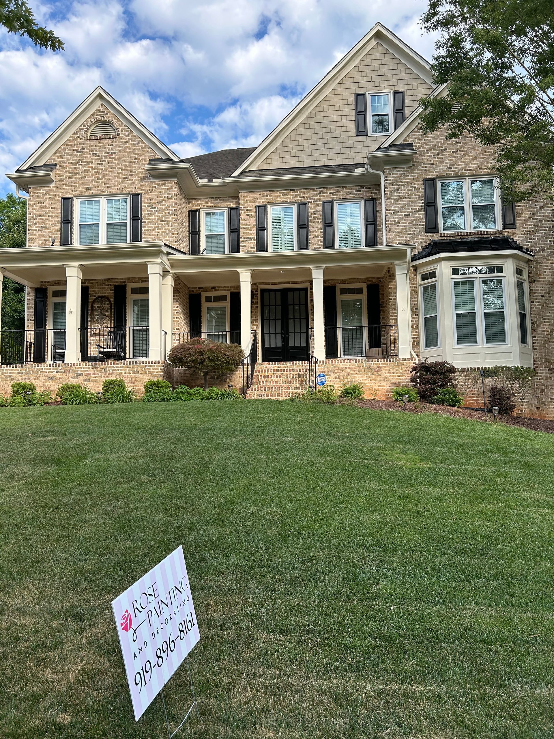 A large brick house with a sign in front of it