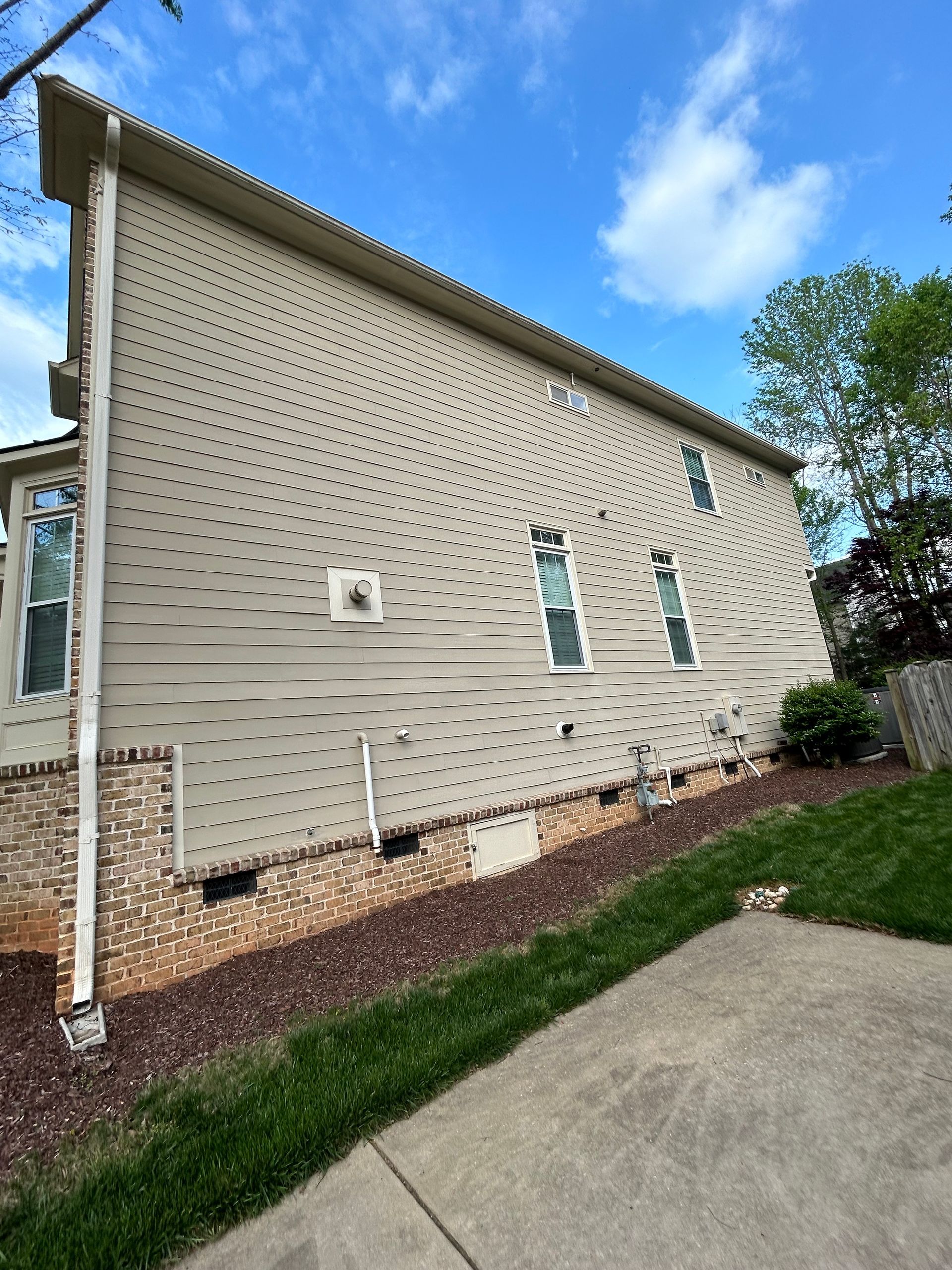 A large brick house with black shutters and a large porch