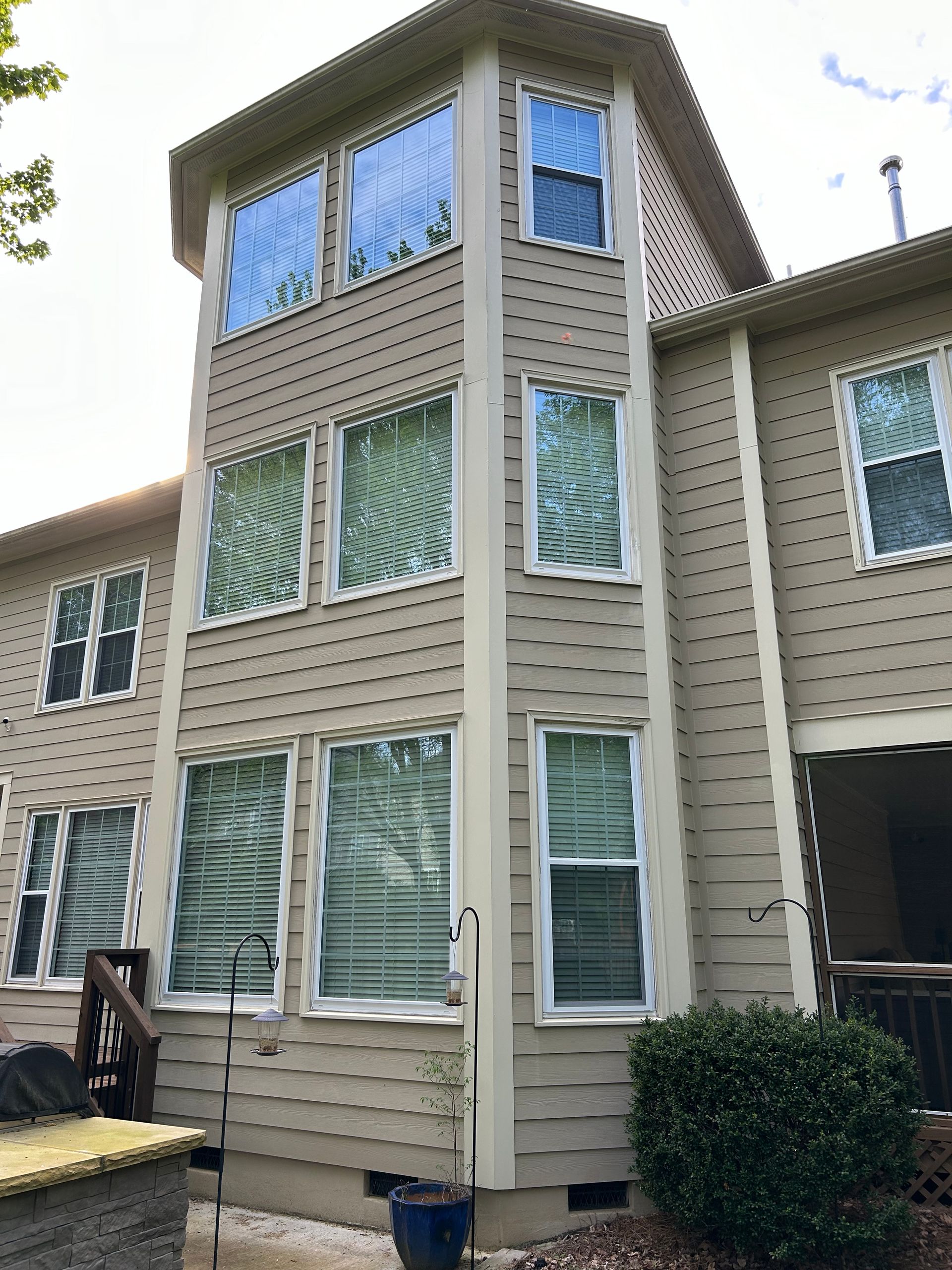 A large house with a lot of windows and a bird feeder in front of it