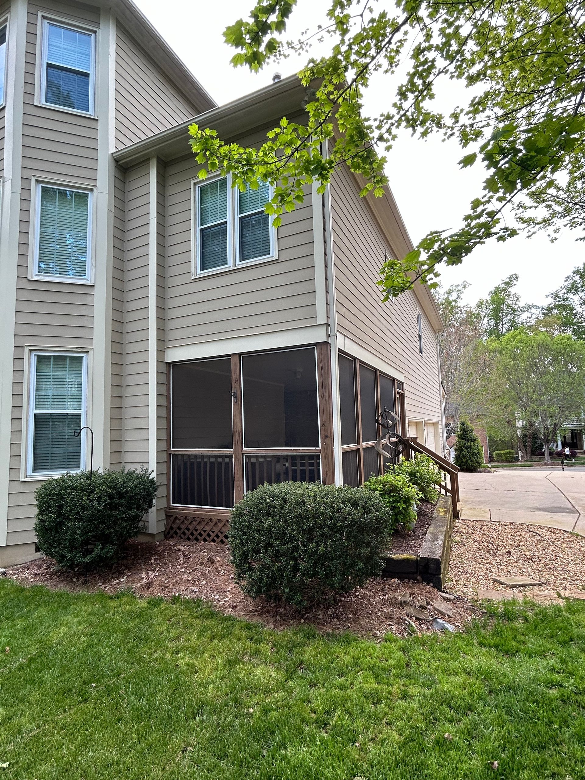 A house with a screened in porch and stairs in front of it