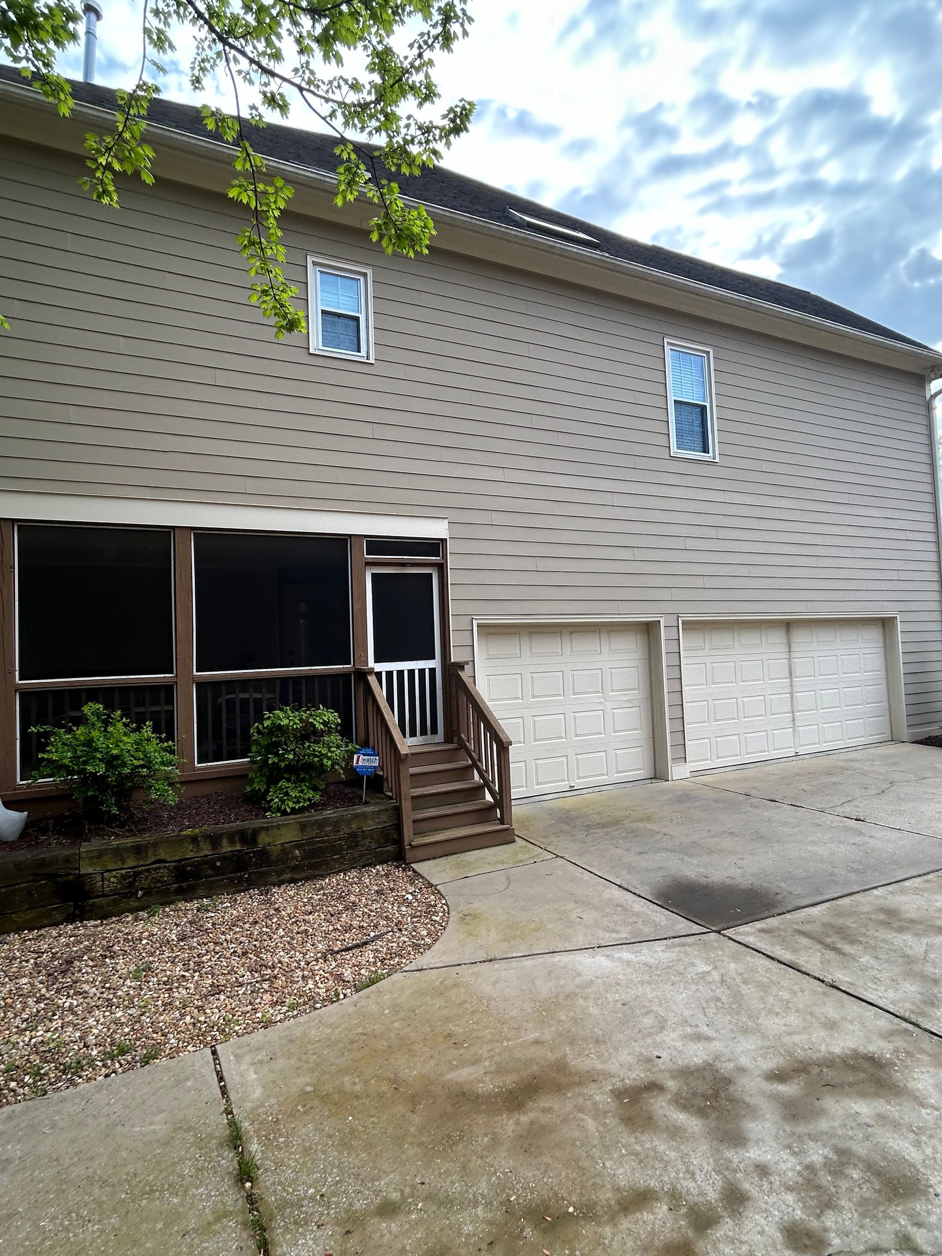A house with a screened in porch and two garages