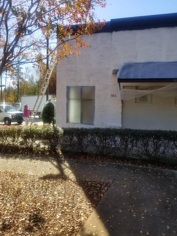 A white building with a black roof is being painted