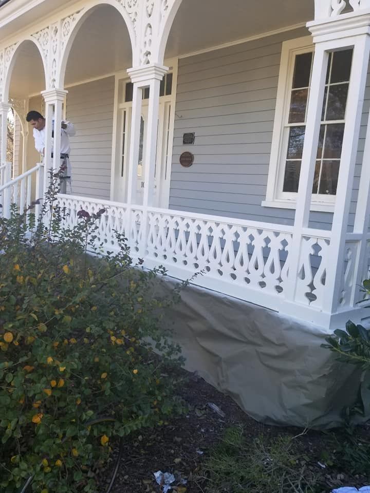 A man is painting the porch of a house