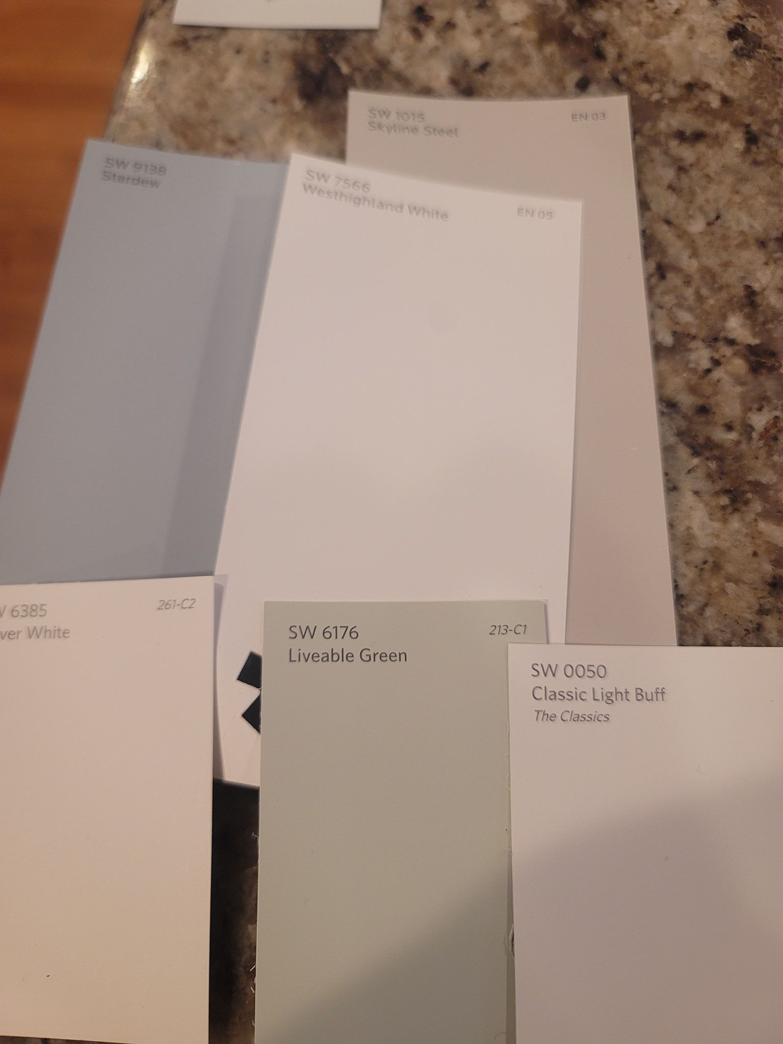 Several samples of paint sit on a granite counter top