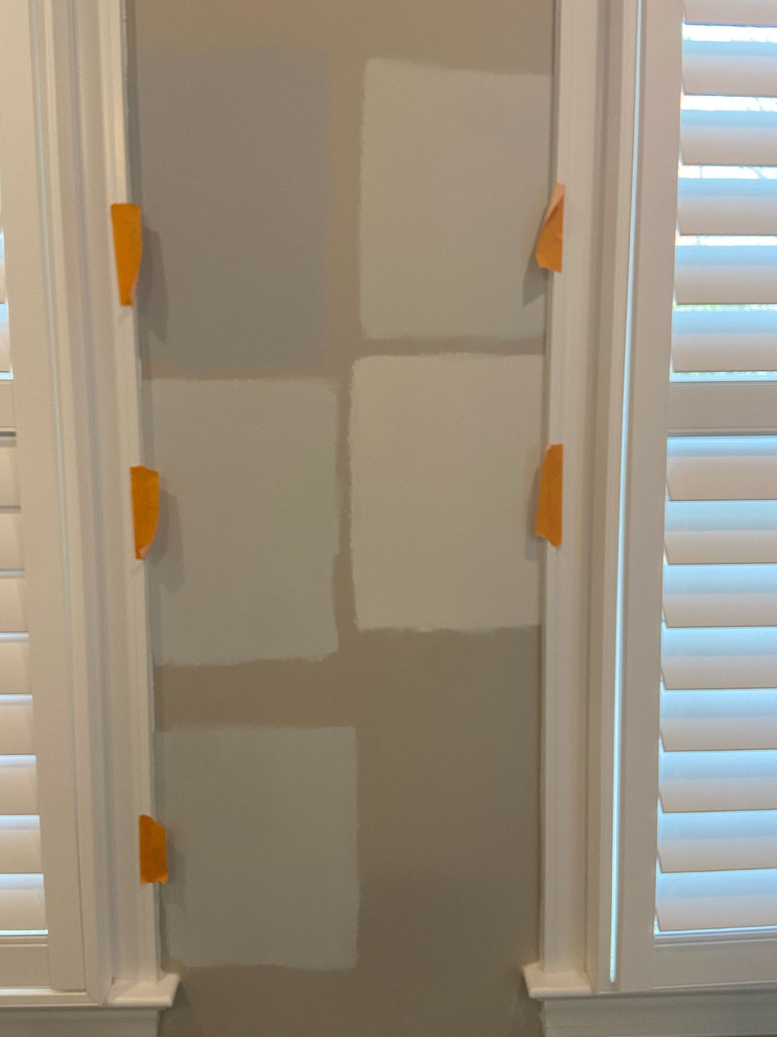 A door is being painted in a room with shutters