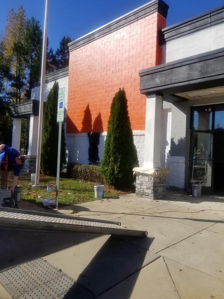A white building with a black roof is being painted