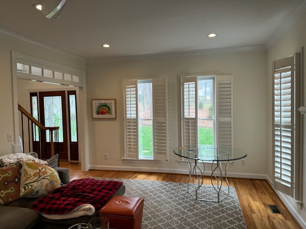 A living room with a couch, table, and shutters on the windows