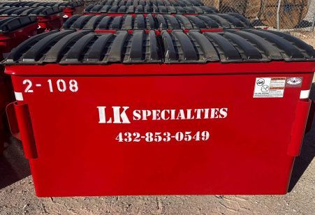 Red dumpster with black lid,