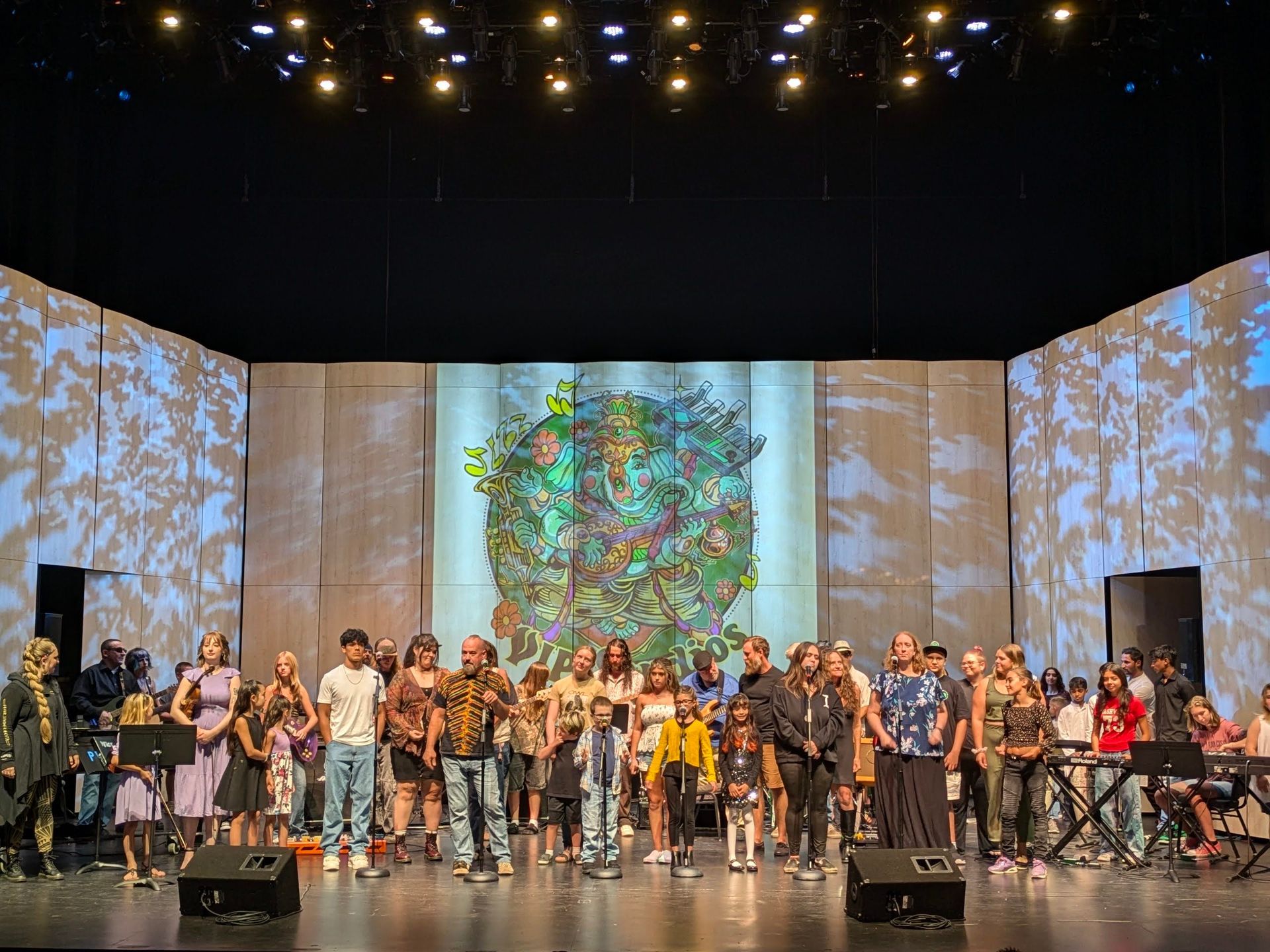 A group of people are standing on a stage in front of a large screen.