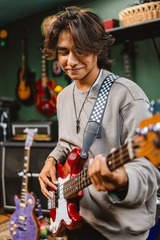 A young man is playing an electric guitar in a garage.