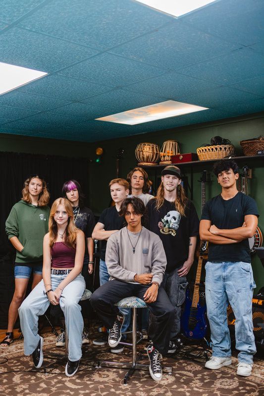 A group of young people are posing for a picture in a room.