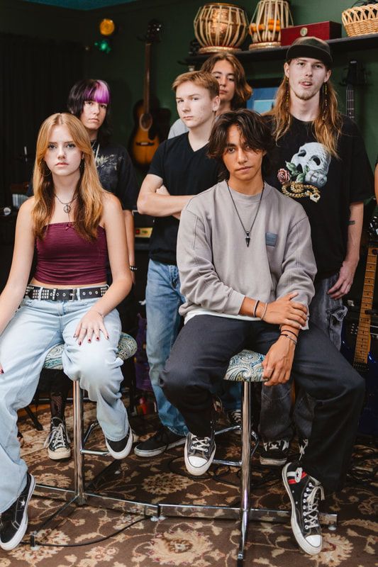 A group of young people are posing for a picture in a room.