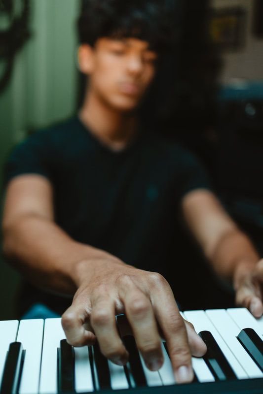 A man in a black shirt is playing a keyboard.