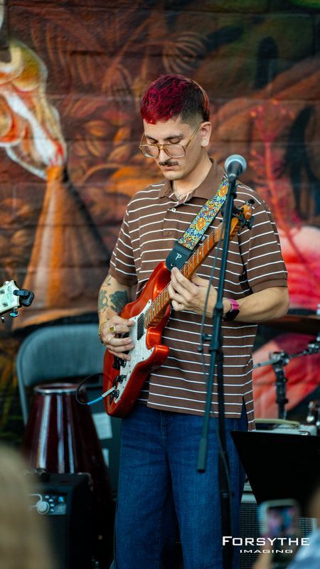 A man is playing a guitar and singing into a microphone.
