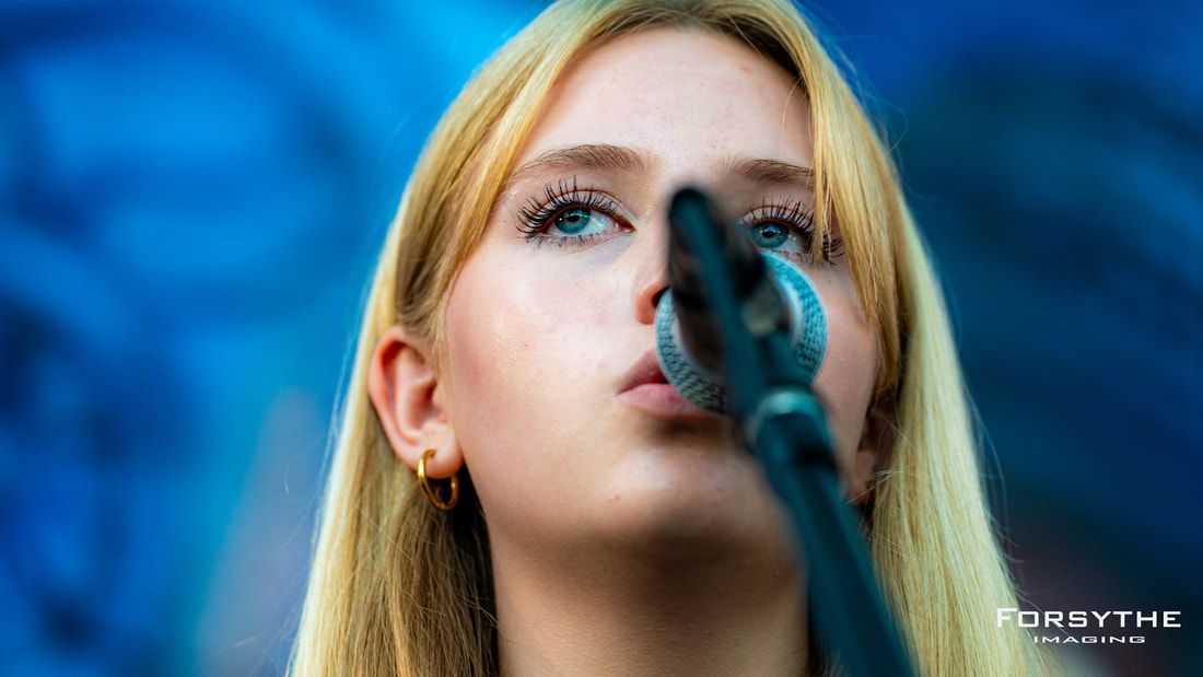 A close up of a woman singing into a microphone