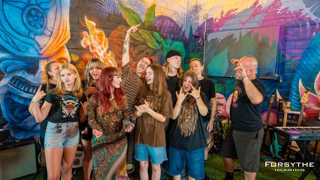 A group of people are posing for a picture in front of a mural.
