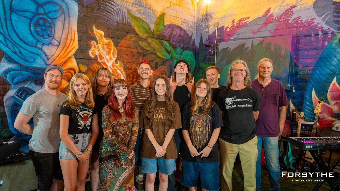A group of people are posing for a picture in front of a mural.
