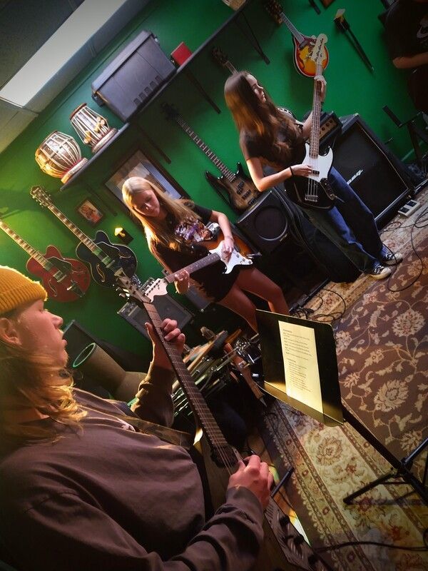 A group of people playing guitars in a room