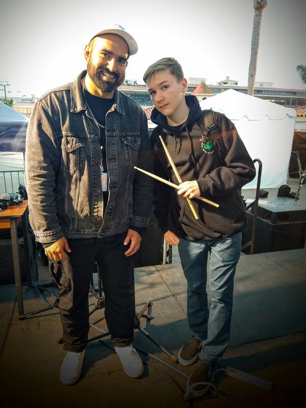 A man and a boy standing next to each other holding drumsticks