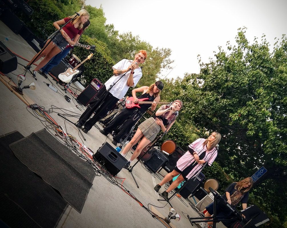 A group of people singing and playing instruments on a stage