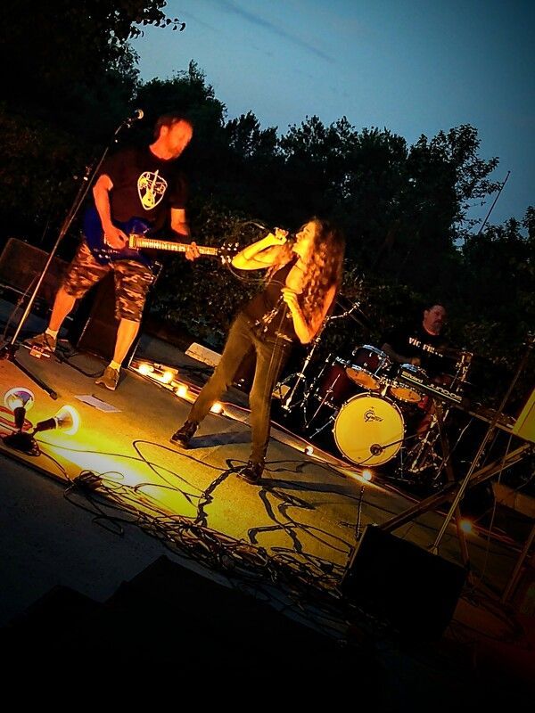 A man playing a guitar and a woman singing on a stage