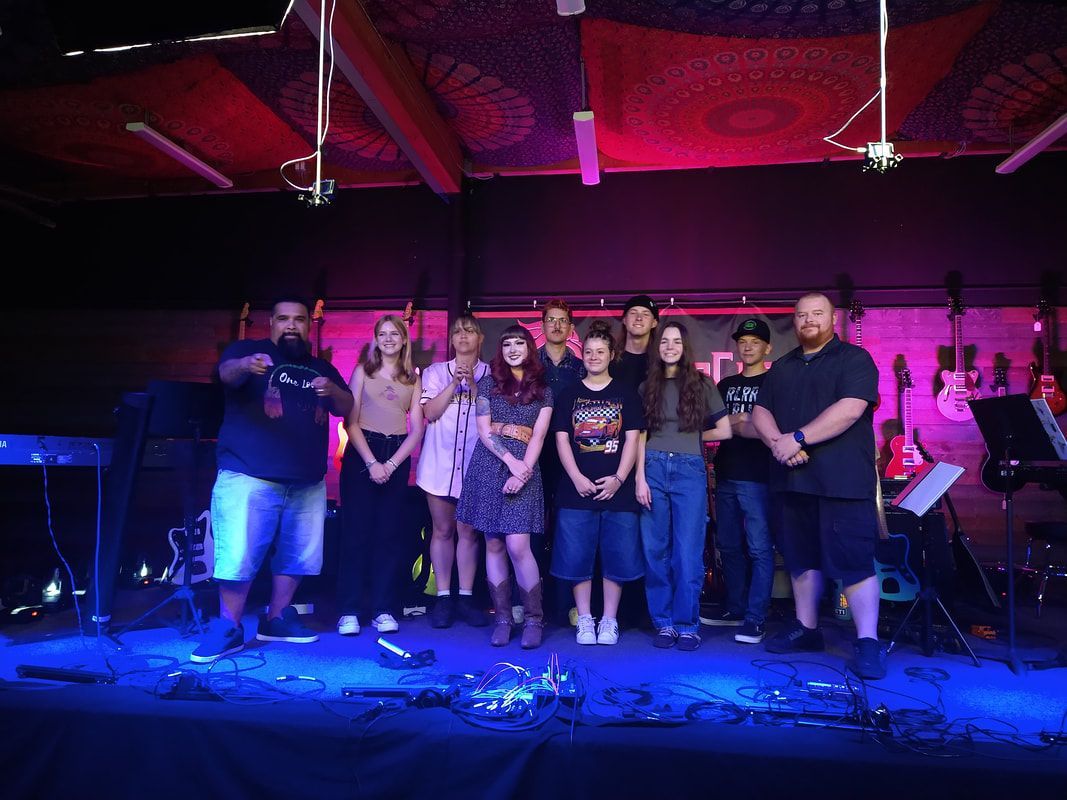 A group of people are standing on a stage in a dark room.
