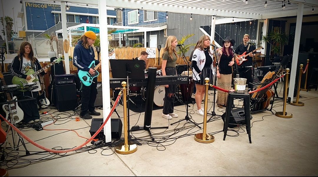 A group of people are standing on a stage playing instruments.