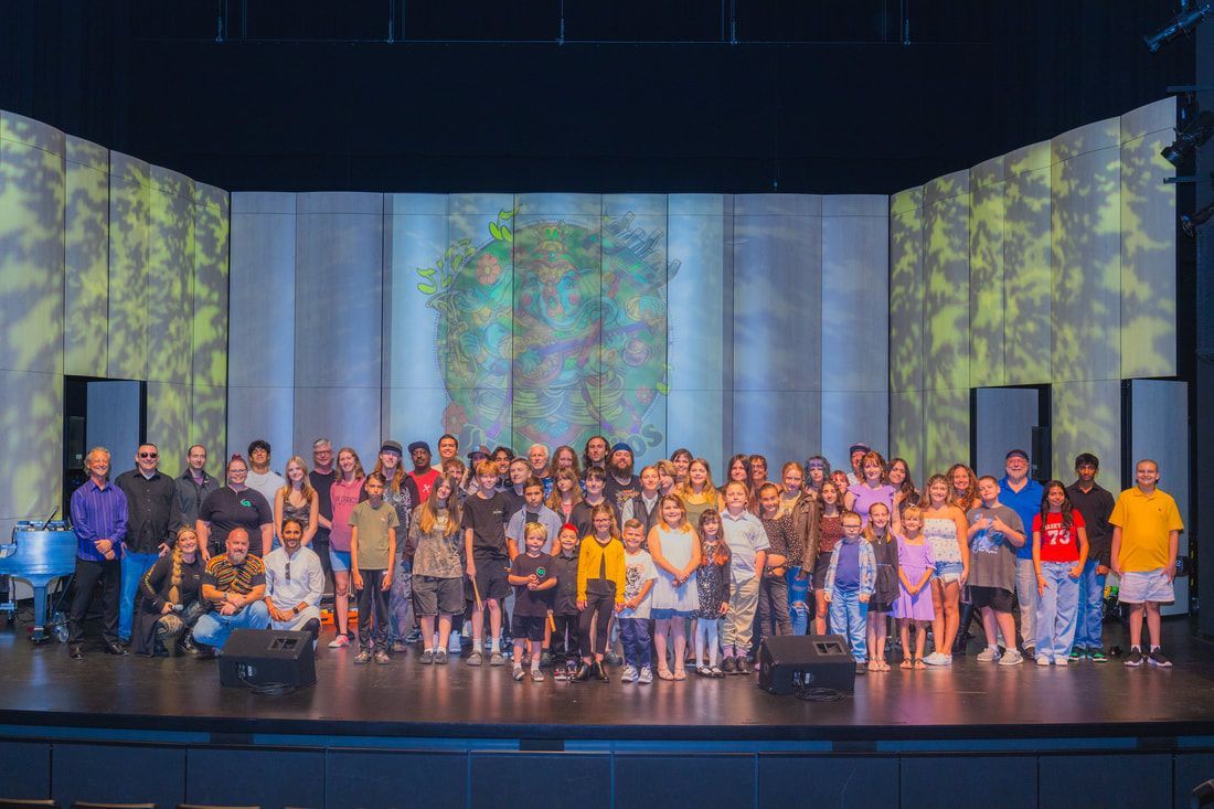 A large group of people are posing for a picture on a stage.