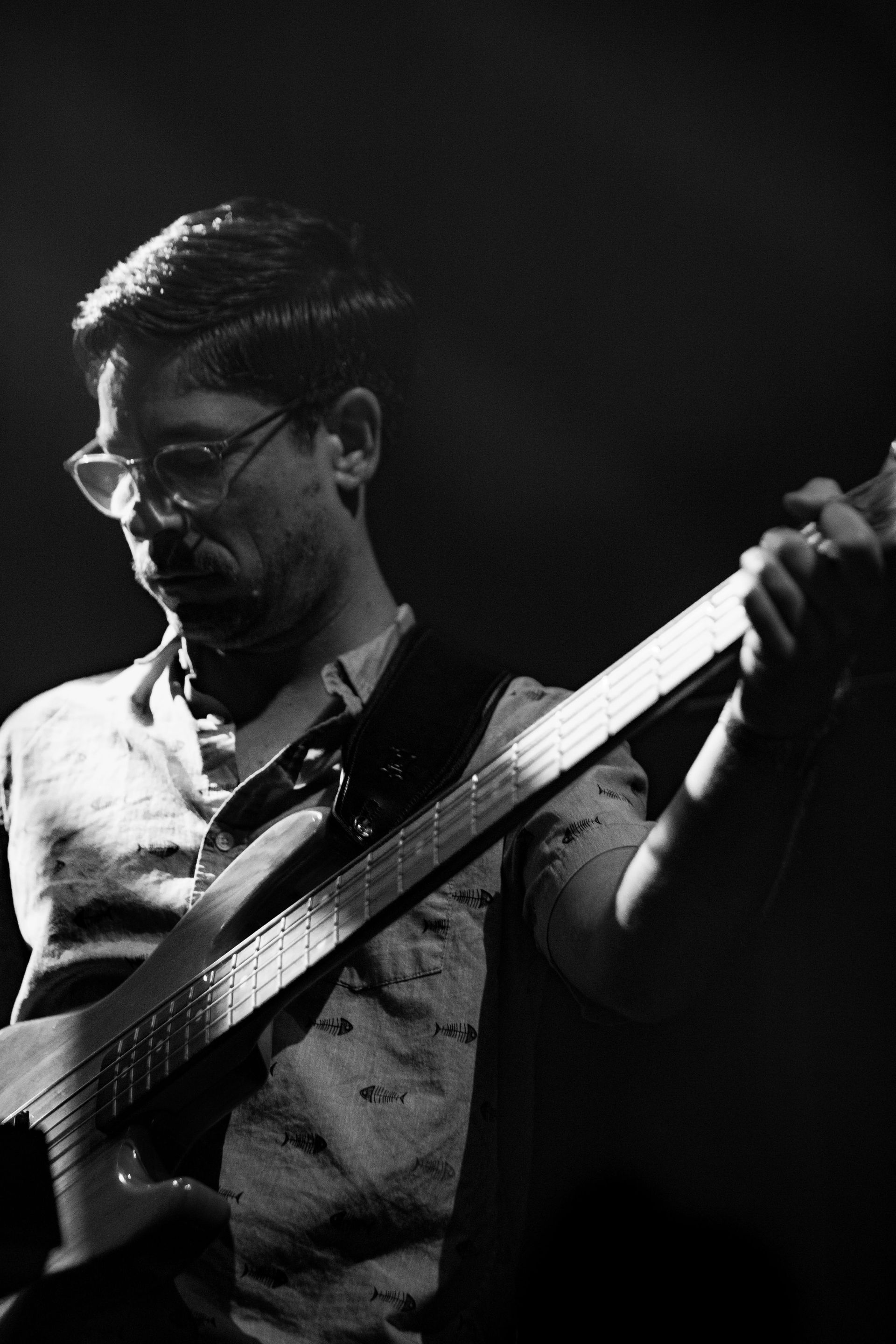A man is playing a guitar in a black and white photo.