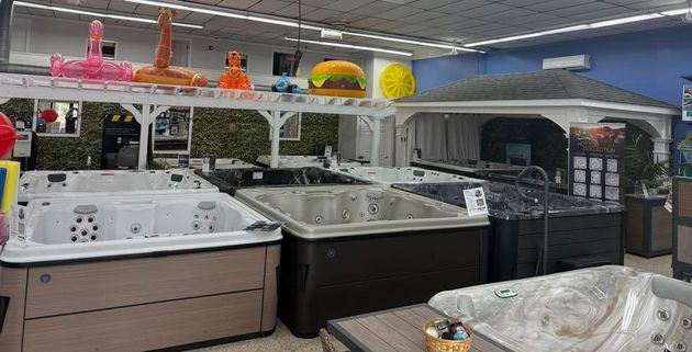 Display of hot tubs in a showroom with colorful inflatable rings on the top shelf