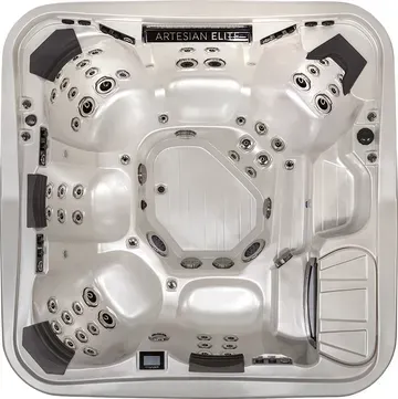 White corner hot tub with multiple jets and black headrests, labeled Artesian Elite.