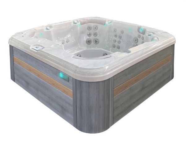 Square gray hot tub with white interior and blue control light