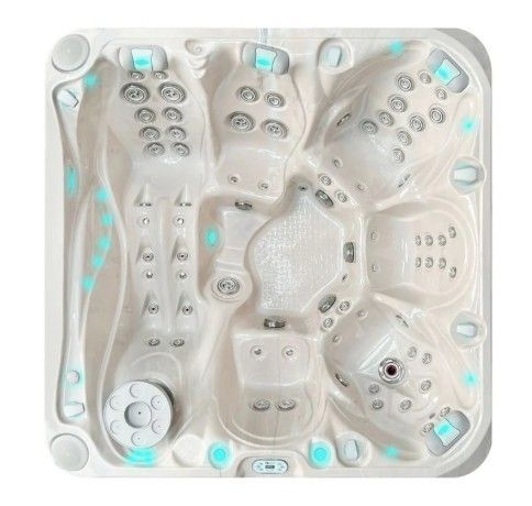 Top view of a white acrylic hot tub with multiple seats, jets, and blue LED lights around the rim