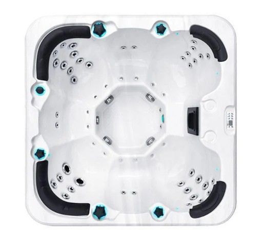 Top view of a white square hot tub with black headrests and blue jets