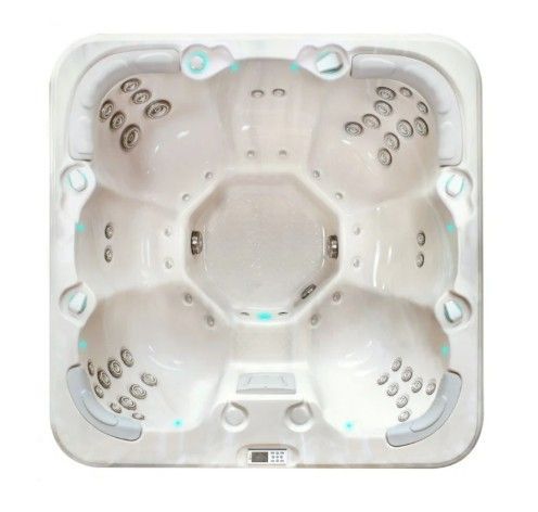 Top-down view of a white square hot tub with molded seats and jets