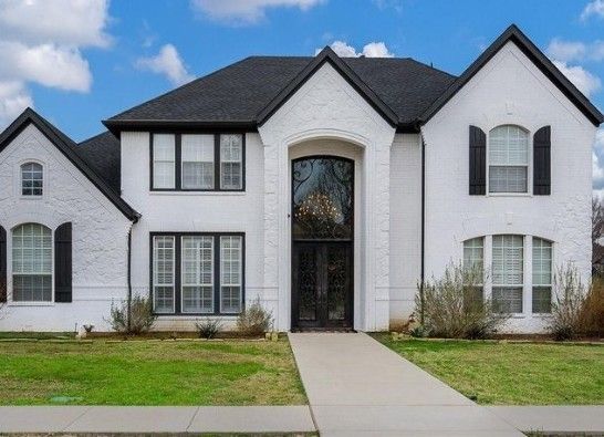 A large white house with black shutters on the windows