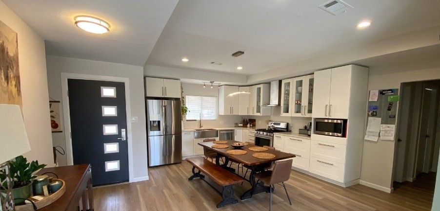 A kitchen with a dining table and bench in it.