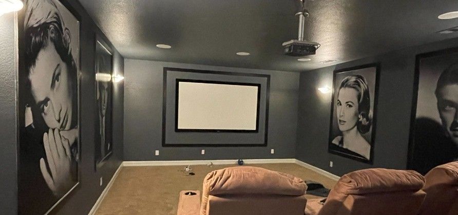 A home theater with a projector and a large screen.