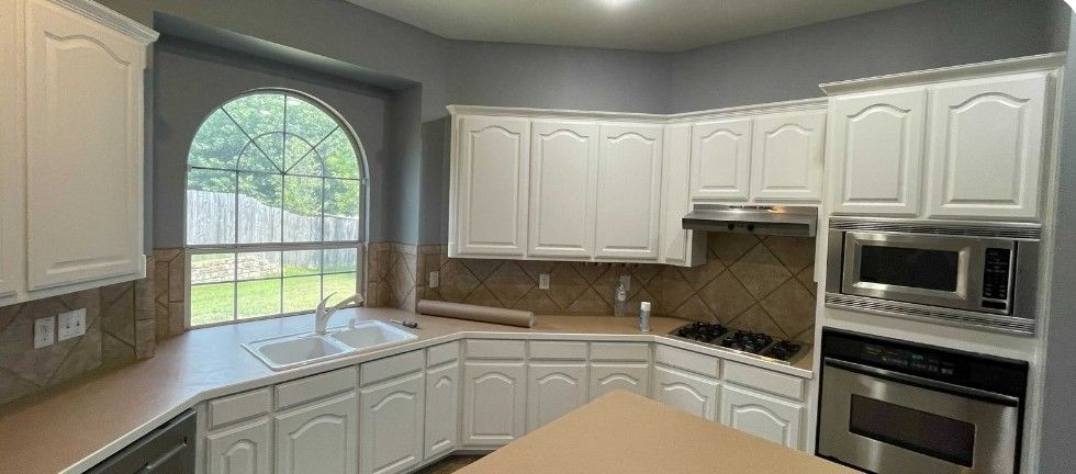 A kitchen with white cabinets and stainless steel appliances.