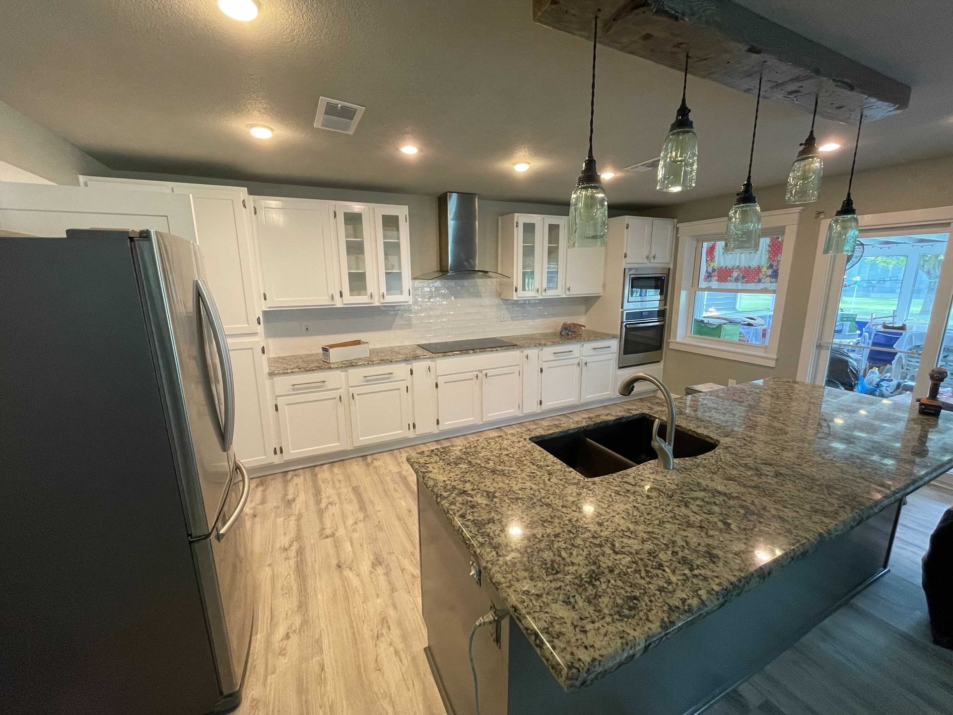A kitchen with granite counter tops and white cabinets.