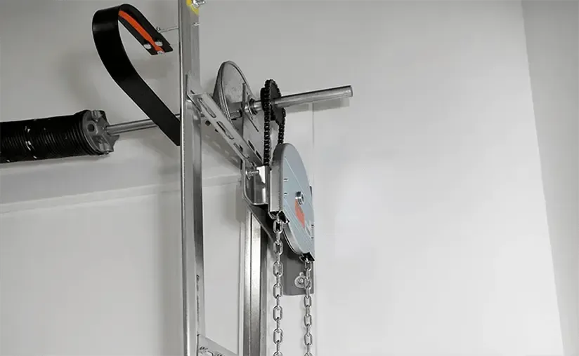 A close up of a machine on a wall with a chain attached to it.