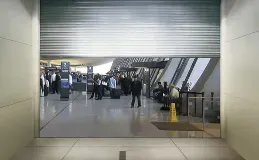 A group of people are standing in an airport waiting area.