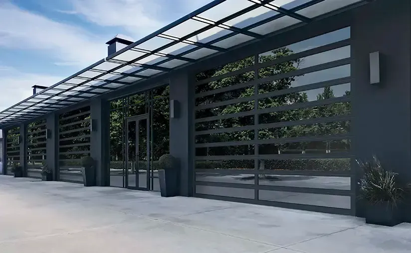 A row of black garage doors with a canopy over them.