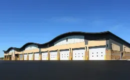 A large building with a lot of garage doors and a blue sky in the background.